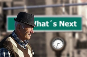 Old Man walking by a What's Next sign